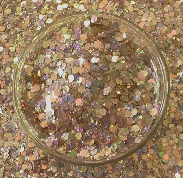 Multicolored glitter in a clear glass container on a glittery background